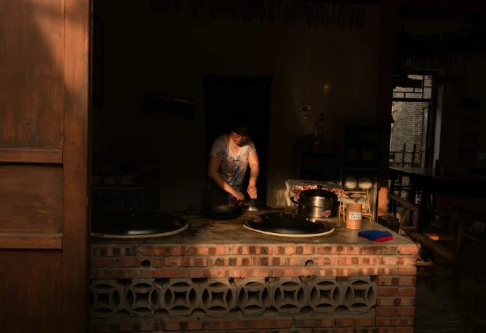 a man is cooking in a brick kitchen